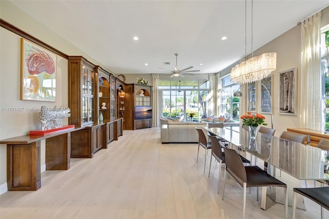 dining area featuring ceiling fan with notable chandelier and light hardwood / wood-style floors