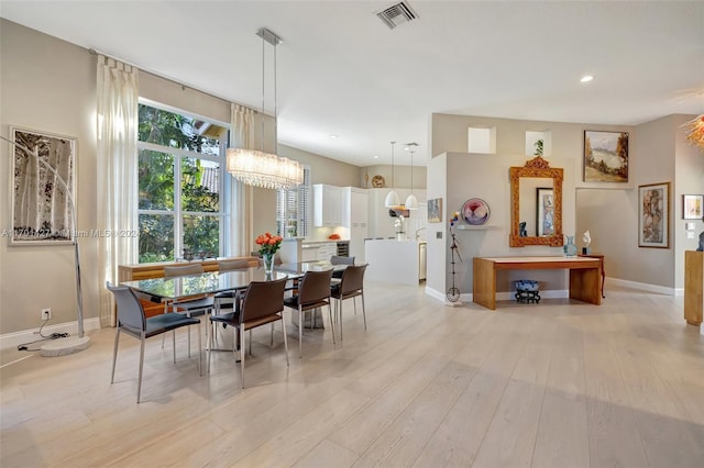 dining room featuring a notable chandelier and light wood-type flooring