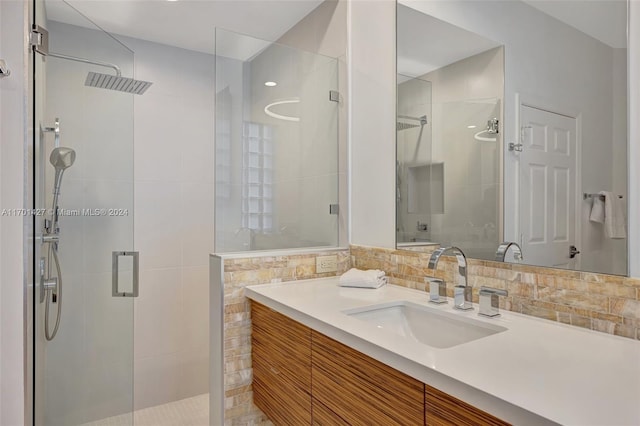 bathroom with vanity, an enclosed shower, backsplash, and tile walls