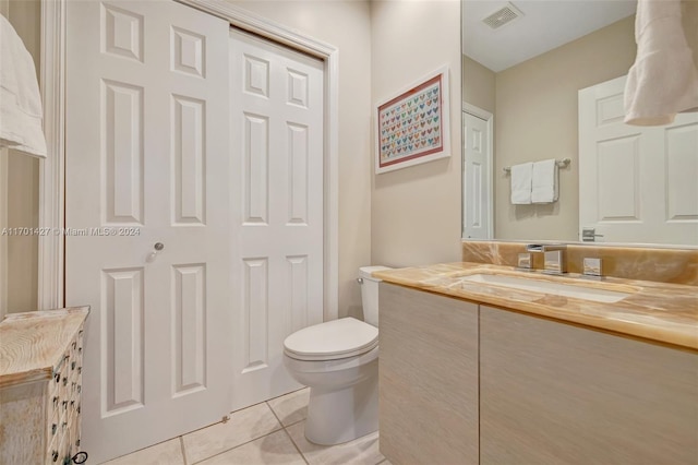 bathroom with tile patterned flooring, vanity, and toilet