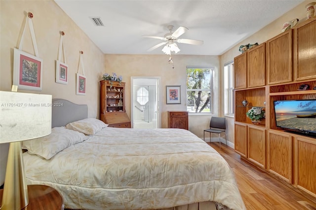 bedroom featuring a textured ceiling, connected bathroom, light hardwood / wood-style floors, and ceiling fan