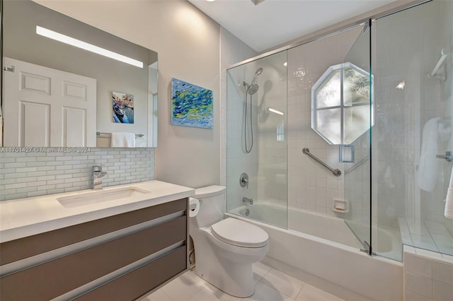 full bathroom with tile patterned flooring, combined bath / shower with glass door, toilet, decorative backsplash, and vanity