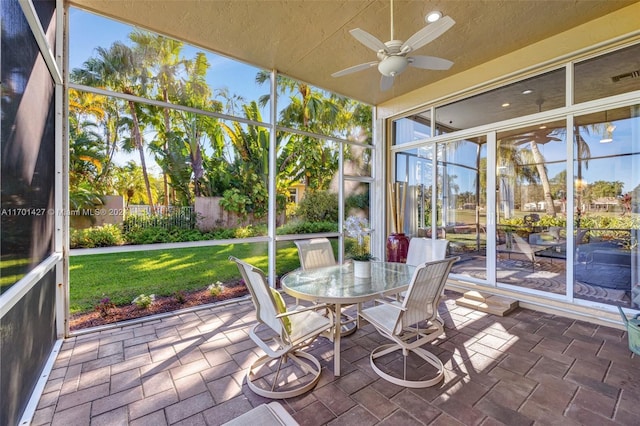 unfurnished sunroom featuring ceiling fan