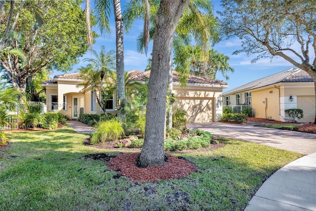 mediterranean / spanish home featuring a front yard and a garage