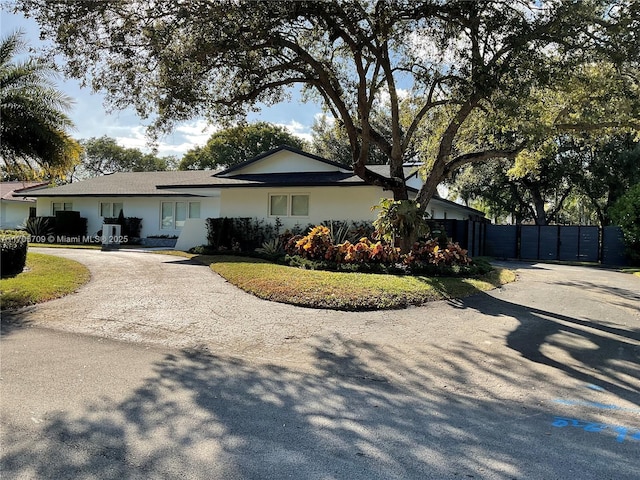 single story home with driveway and fence