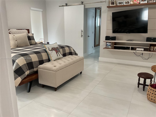 bedroom with light tile patterned floors and a barn door