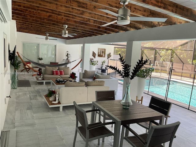 dining area featuring lofted ceiling with beams, ceiling fan, and wooden ceiling