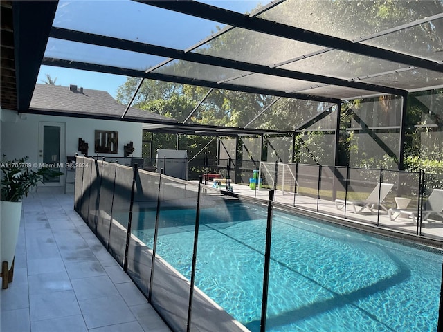 view of pool featuring glass enclosure and a patio