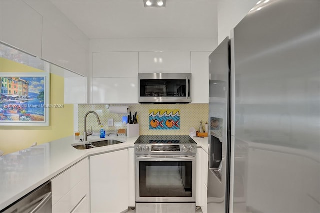 kitchen featuring white cabinetry, sink, appliances with stainless steel finishes, and tasteful backsplash