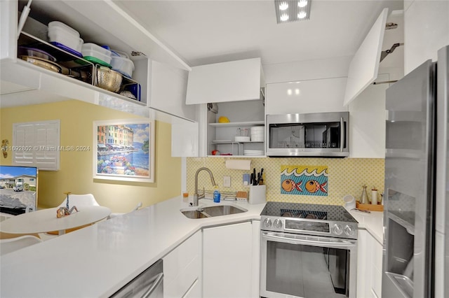 kitchen with decorative backsplash, white cabinetry, sink, and stainless steel appliances