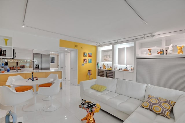 living room featuring light tile patterned flooring, sink, and wine cooler