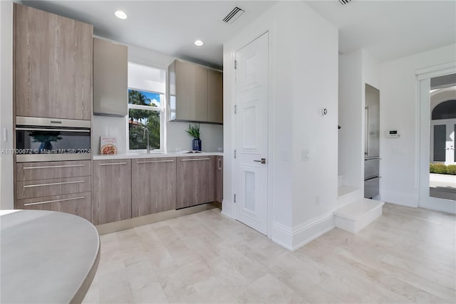 kitchen with oven, a healthy amount of sunlight, and sink