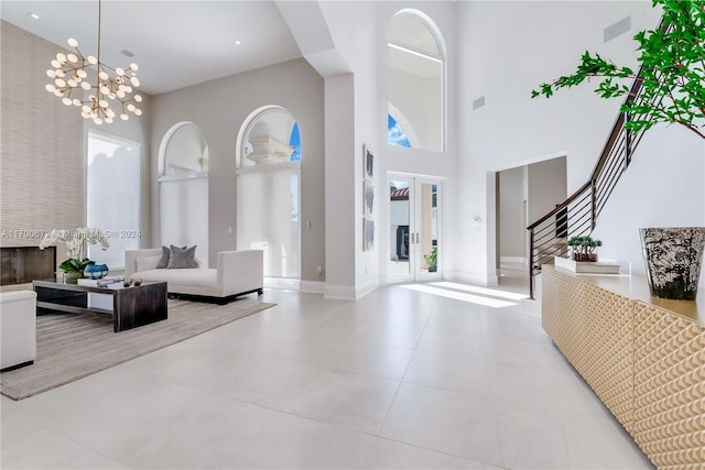 tiled entrance foyer with a notable chandelier and a towering ceiling