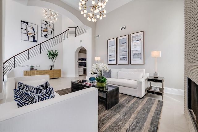 living room featuring tile patterned floors, a high ceiling, and a notable chandelier