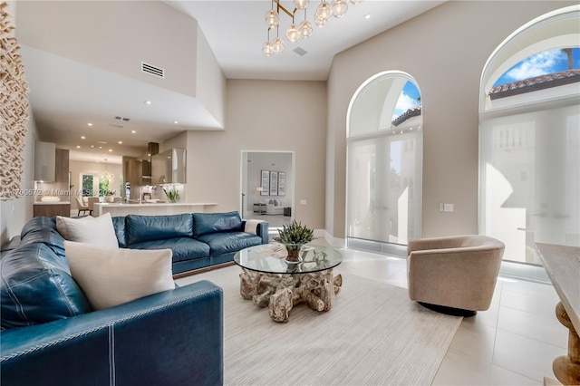 tiled living room with a high ceiling and an inviting chandelier