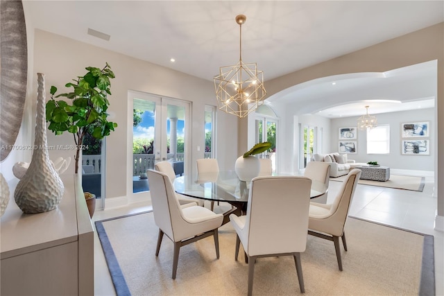 tiled dining area with french doors and a chandelier