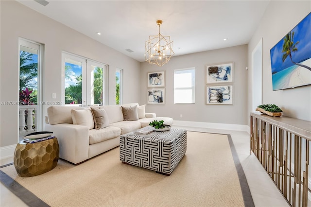 carpeted living room featuring french doors and a notable chandelier