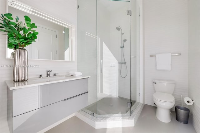 bathroom with tile patterned floors, toilet, vanity, and walk in shower