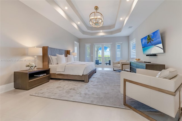 bedroom with french doors, access to outside, a tray ceiling, and a notable chandelier