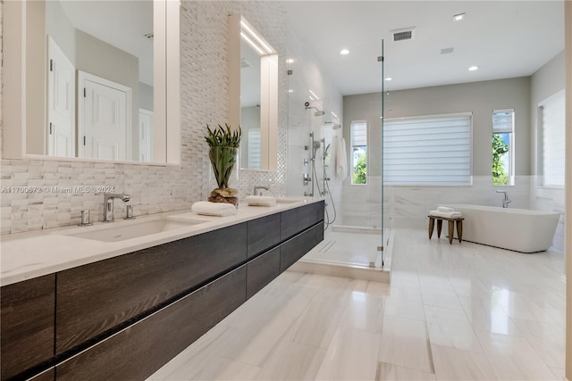 bathroom featuring vanity, a healthy amount of sunlight, independent shower and bath, and tasteful backsplash