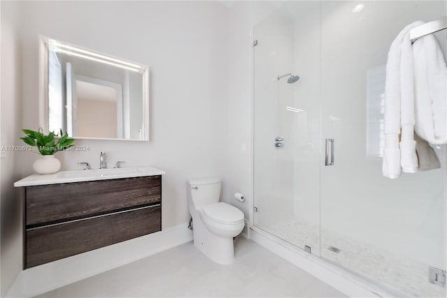 bathroom with vanity, toilet, and a shower with door