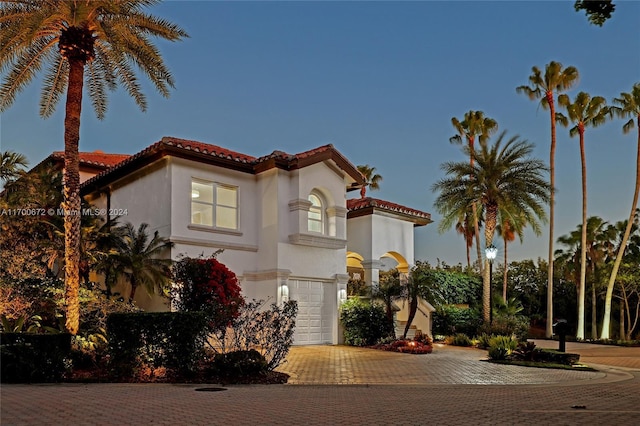 mediterranean / spanish home featuring a garage