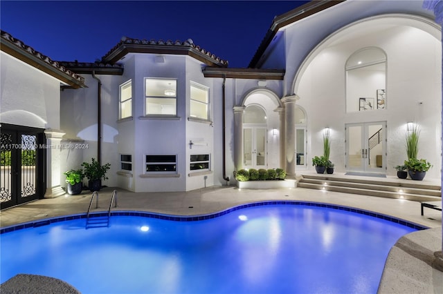 pool at night with french doors