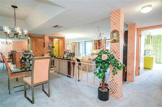 dining area featuring a textured ceiling, light colored carpet, and a notable chandelier