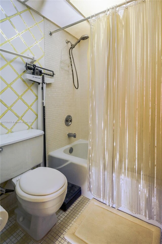 bathroom with tile patterned floors, shower / bath combo with shower curtain, and toilet