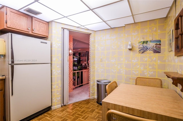 kitchen with parquet floors, a paneled ceiling, and white fridge