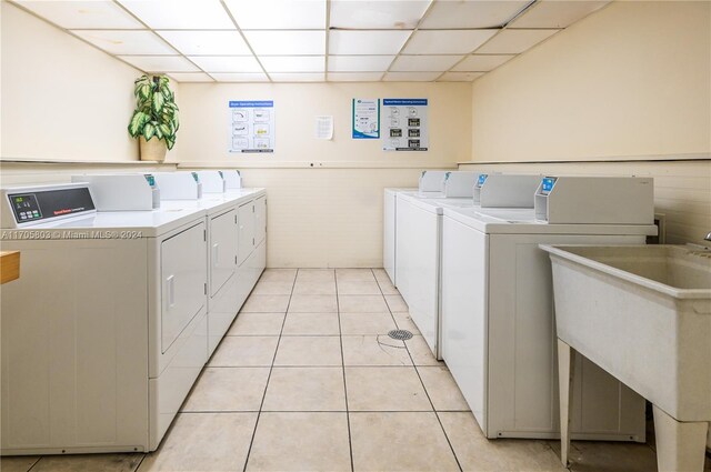 laundry area featuring separate washer and dryer, sink, and light tile patterned floors