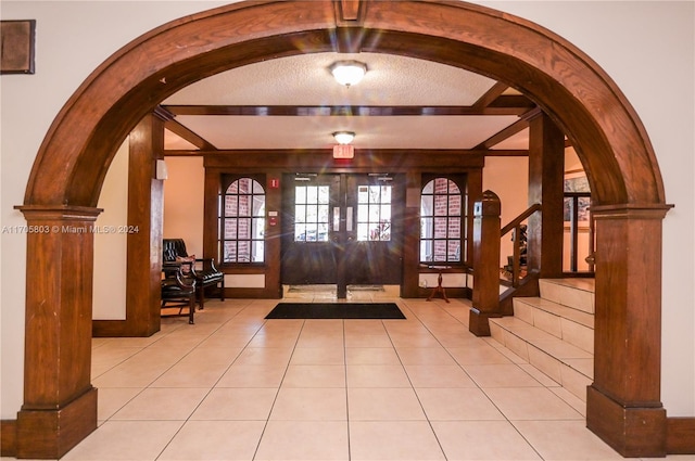 entryway with vaulted ceiling with beams, french doors, and light tile patterned floors