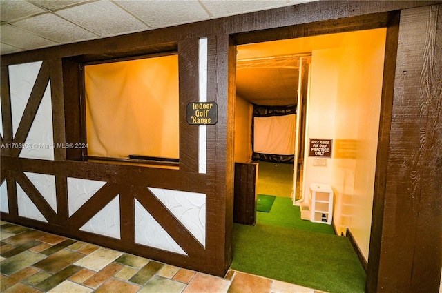 corridor with carpet and a drop ceiling