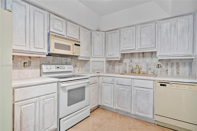 kitchen featuring white cabinets, light tile patterned floors, white appliances, and sink