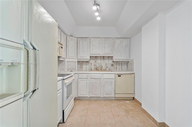 kitchen with white appliances, sink, tasteful backsplash, light tile patterned flooring, and white cabinetry