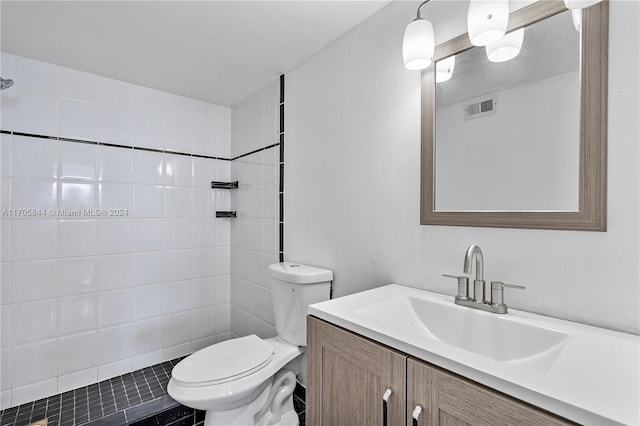 bathroom featuring vanity, toilet, and tiled shower