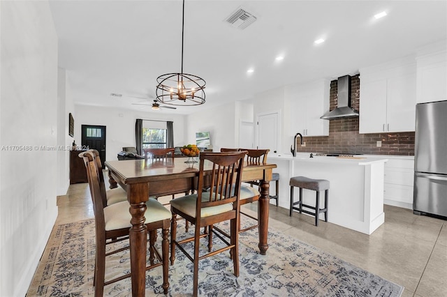 dining room featuring ceiling fan with notable chandelier and sink