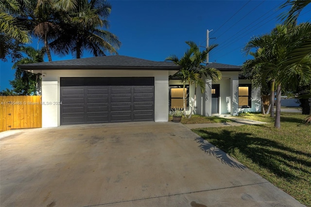 ranch-style home with a front lawn and a garage