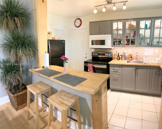 kitchen with black fridge, sink, stainless steel electric range oven, and gray cabinets