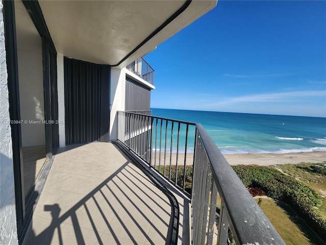 balcony featuring a water view and a beach view