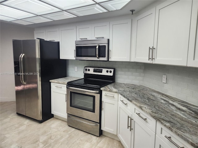 kitchen with backsplash, white cabinetry, light stone counters, and appliances with stainless steel finishes