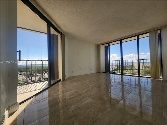 unfurnished room featuring expansive windows and a textured ceiling