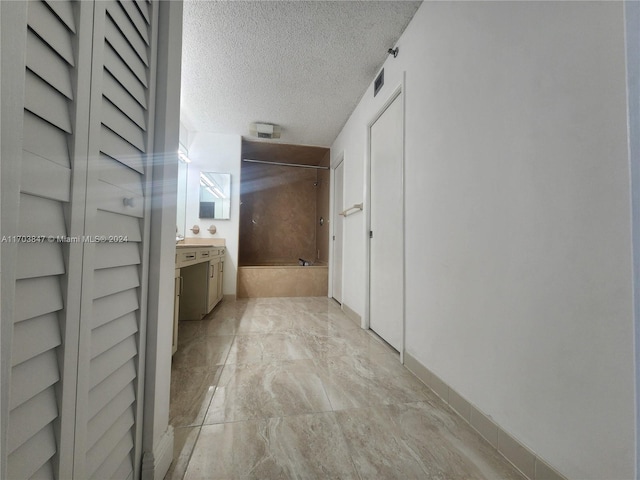 hall featuring a textured ceiling