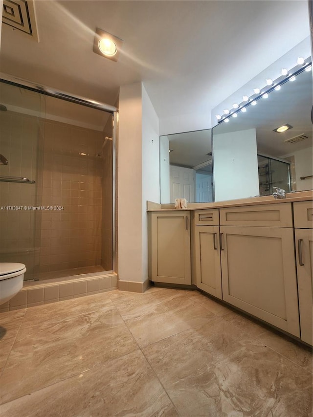 bathroom featuring vanity, toilet, and an enclosed shower