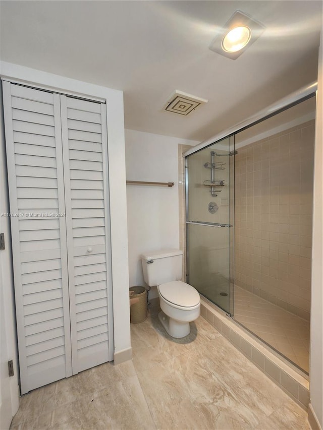 bathroom with toilet and an enclosed shower