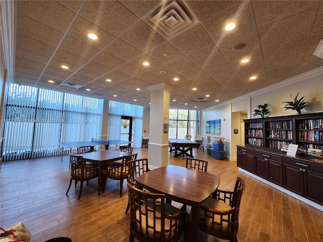 dining space with wood-type flooring and ornamental molding