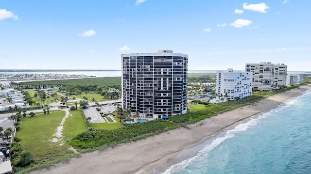 birds eye view of property with a water view and a beach view