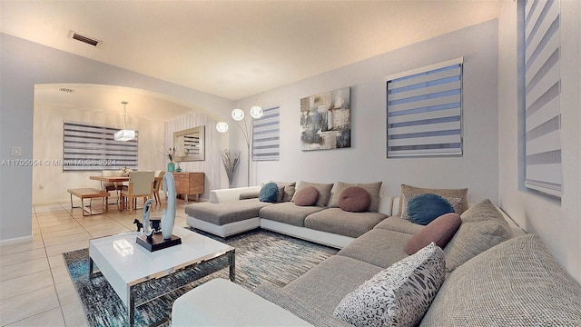 living room with a chandelier and light tile patterned flooring