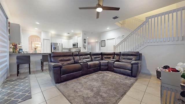 living room featuring light tile patterned floors and ceiling fan