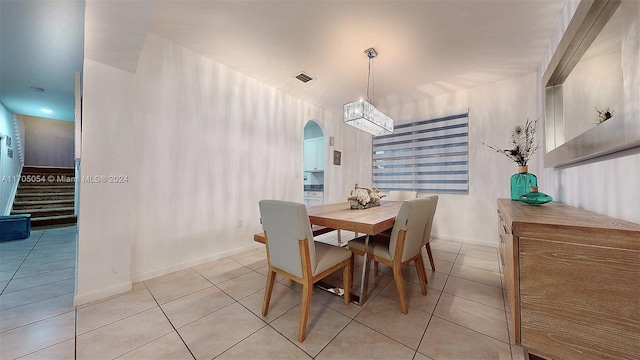 tiled dining room with a chandelier